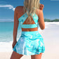 Large print conservative swimwear skirt in turquoise, worn by a woman on the beach, showcasing a stylish and comfortable design.